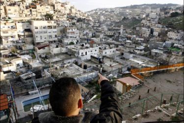 afp : A Palestinian man points towards Silwan neighbourhood in annexed east Jerusalem on February 22, 2009, where around 80 houses in the Bustan area are threatened to be