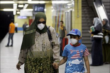 r : A women and her son wear face masks in an underground train station in Cairo June 14, 2009. Egypt, hard hit by the more deadly H5N1 bird flu virus, detected its first
