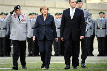 afp : The Inspector General of the Bundeswehr Wolfgang Schneiderhan, German Chancellor Angela Merkel and German Defense Minister Franz Josef Jung review soldiers