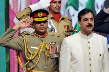 Pakistani Prime Minister Yousuf Raza Gilani (R) stands to attention during the playing of the national anthem at the flag hoisting ceremony in Islamabad on August 14, 2009, to mark the country’s Independence Day.
