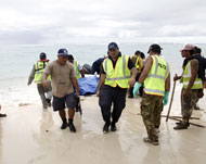 رجال شرطة من ساموا ينقلون جثة رجل انتشلت من البحر جراء تسونامي الذي ضرب الجزر (الفرنسية)