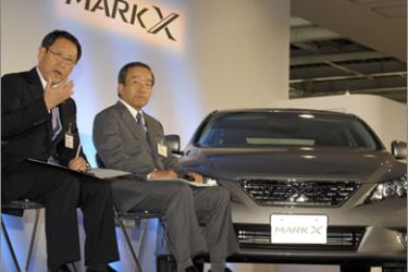 Toyota Motors President Akio Toyoda (R) answers a question beside vice President Takeshi Uchiyamada (R) beside the company's new Mark X sedan during a press preview in Tokyo on October 19, 2009. Toyota launched the new domestic model
