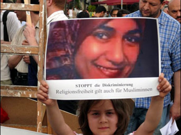طفلة مسلمة ترفع صورة لمروة الشربيني خلال تظاهرة في برلين . الجزيرة نت