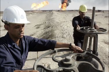 r : Workers adjust the valves of an oil pipe in south Rumaila oil field, in southern Iraq December 2, 2009. Picture taken December 2, 2009. REUTERS/Atef Hassan (IRAQ