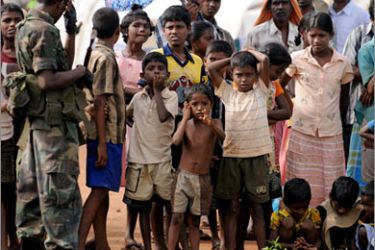 FILES) In this picture taken on November 21, 2009, Sri Lankan war-displaced civilians look on at a state-run internment camp in Vavuniya. Thousands