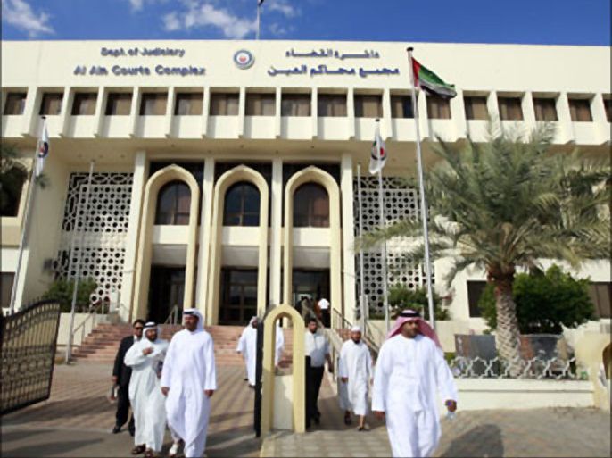 r : People walk past a court in AL-Ain January 10, 2010. Sheikh Issa bin Zayed al-Nahyan, a member of Abu Dhabi's ruling family, was found innocent on Sunday of the torture