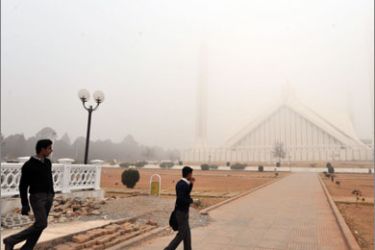 Pakistani visitors look at the fog covered Grand Faisal mosque in Islamabad on January 7, 2010.