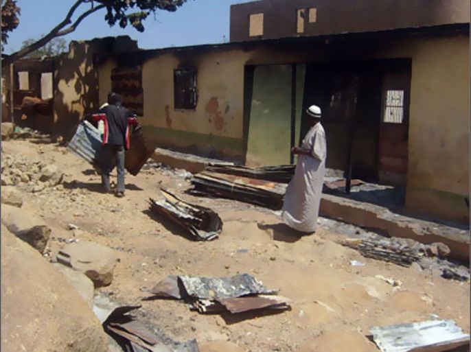 A picture taken on January 24, 2010 shows Muslim residents salvaging corrugated metal roofing sheets from burnt out buildings in Dutse Uku in the Nassarawa Gwom district city of Jos, the epicentre of the four-day christian-muslim sectarian violence which left about 400 dead and 18,000 residents displaced.
