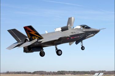 r : The first Lockheed Martin F-35B Lightning II short takeoff, vertical landing (STOVL) stealth fighter, piloted by Graham Tomlinson, demonstrates the capability to hover during a test