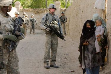 r_Afghan women walk past U.S. Army soldiers with the 293D Military Police Company, 97th Military Police Battalion, patrolling on the outskirts of the town of Kandahar, southern Afghanistan