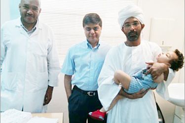 عمار عجول حاملا طفله وعن يمينه الدكتور أنيل دوان والكتور حاتم عبد الرحمن