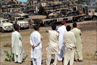 afp : Pakistani truck owners gather near the burnt out wreckage of NATO supply trucks carrying military vehicles and fuel following an attack on the outskirts of Islamabad on
