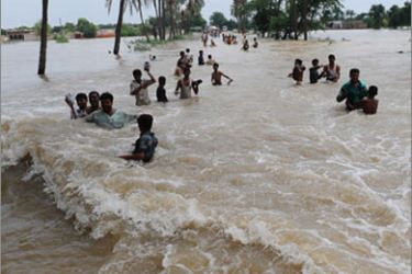Pakistani villagers cross a flooded area of Bssera village near Muzaffargarh on August 11, 2010. Pakistan issued fresh flood warnings August 11, putting parts of Punjab and Sindh on alert and calling on foreign donors to step up efforts to contain the country's worst