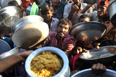 Flood-displaced Pakistanis receive food at a distribution point at an Air force relief camp in Sukkur on August 18, 2010. The Organisation of the Islamic Conference on August 18 called on member states and the international community to supply urgent aid to Pakistan, which is grappling with devastating floods. AFP