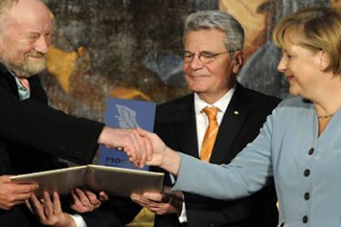 Danish cartoonist Kurt Westergaard (L) is congratulated on his prize by German Chancellor Angela Merkel (R)