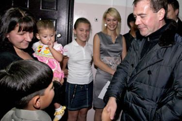 Russian President Dmitry Medvedev (R) shakes hands with a boy as he visits a family in Yuzhno-Kurilsk during his visit to Kunashir one of the Kuril islands on November 1, 2010.