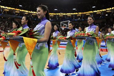 Podium assistants attend the medal ceremony after the China-South Korea basketball final at the Guangzhou international sport