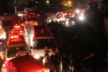 epa02469719 Ambulance and firefighters gather at the scene where a cargo plane was crashed in a residential area in southern port city of Karachi,