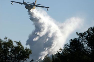 r_A fire-fighting aircraft from Turkey drops water over a forest fire near Ein Hod, on Mount Carmel near the northern city of Haifa December 5, 2010. Israeli Prime Minister Benjamin