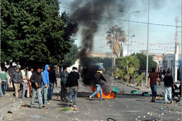 Tunisian demonstrators move along a street during clashes with security forces in Regueb, near Sidi Bouzid on January 10, 2011. Tunisian President Zine El Abidine Ben Ali blamed weekend rioting that left at least 14 people dead on "gangs of thugs",