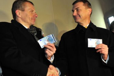 Estonian Prime Minister (R) and Financial Mnister Jürgen Ligi hold euro notes on January 1, 2011 in Tallinn, Estonia. Estonia adopted the European single currency at midnight, ringing in 2011 as the 17th member of the eurozone, a bloc threatened by bailouts in Greece and Ireland and debt woes in Portugal and Spain.