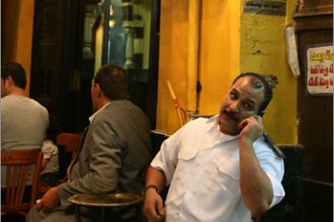 epa02359829 An Egyptian speaks on the phone as he waits for his tea outside al-Fishawi cafe in Khan al-Khalili bazaar, Cairo, Egypt, 26 September 2010. Al-Fishawi is Egypt's
