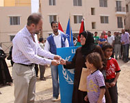 مدير المشروع يسلم المفتاح لسيدة من سكان المخيم (الجزيرة نت)