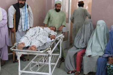 A wounded man is transported at a hospital after a roadside bomb blast in the Panjwai district of Kandahar May 24, 2011. Ten Afghan construction workers were killed and 28 wounded when their truck hit a roadside bomb in the Panjwai district of southern Kandahar province, said Kandahar health official Abdul Qayum Pukhla.
