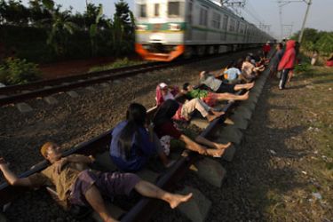 r_Residents lie on railway tracks in Rawa Buaya in Indonesia's West Java province July 13, 2011. The residents believe that the electrical energy from the tracks will cure them of various illnesses. REUTERS