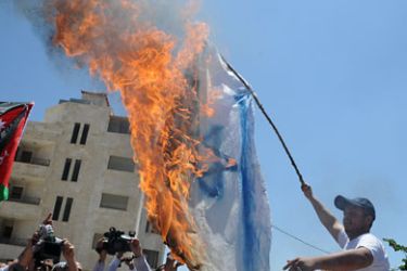 شاب يحرق العلم الاسرائيلي بالقرب من السفارة الاسرائيلي في عمان