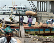 عمال بنغلاديشيون يفرغون أكياس بطاطس في ميناء قرب العاصمة دكا (الفرنسية-أرشيف)