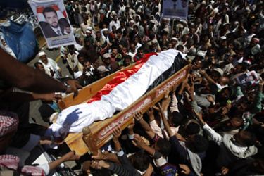 R_Anti-government protesters carry the body of fellow protester Muaffaq Saghir (pictured in poster) during his funeral one day after was killed by a sniper at Taghyeer (change) Square