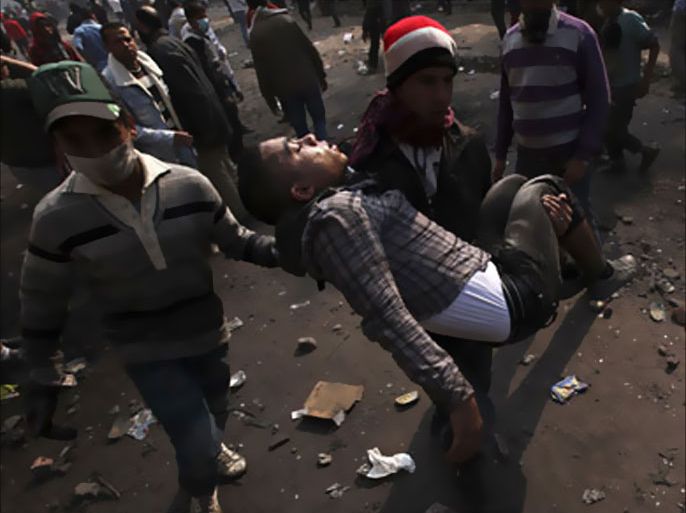 R_An injured protester is carried during clashes with riot police along a road which leads to the Interior Ministry, near Tahrir Square in Cairo November 22, 2011