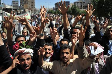 Yemeni anti-government protesters shout slogans during a march to demand the ousting of Yemeni President