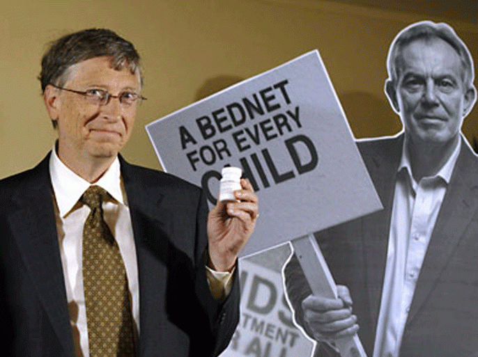 Microsoft founder and billionaire philanthropist Bill Gates hold a medecine while posing next to a cut out of former British Prime Minister Tony Blair to promote the Global Fund's 10th anniversary during the World Economic Forum (WEF) annual meeting on January 26, 2012 in Davos