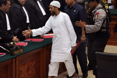 Top Muslim militant Umar Patek shake hands with government prosecutors after the adjournment of his trial at Jakarta court on February 13, 2012