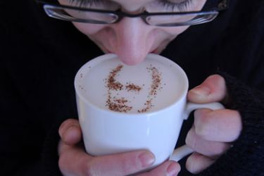 A coffeehouse client holds a cup of cappuccino with the portrait of Vladimir Putin created with cinnamon and cocoa powder sprinkled on the cappuccino's foam in Moscow, on February 1, 2012. The strongman prime minister is seeking to win back his old Kremlin job in March presidential elections in the face of an outburst of protests against his 12-year rule