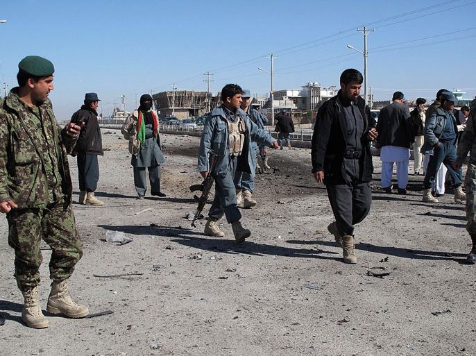 Afghan policemen inspect the site of a suicide attack in the city of Lashkar Gah, Helmand province on February 29, 2012