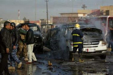 Iraqi security forces collect debris following a blast in Mansur in west Baghdad on February 23, 2012