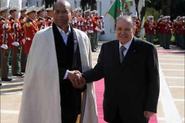 Tunisian President Moncef Marzouki (L) shakes hands with Algeria's President Abdelaziz Bouteflika (R) in Algiers, as part of his first official visit and the final stage of a tour of the