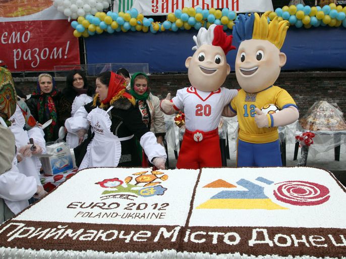epa03123253 The mascots of the EURO 2012 European Soccer Championship pose next to a giant cake with championship logo in Donetsk, Ukraine, 26 February 2012. The 2 x 1.18 meter cake reading 'Donetsk is a EURO 2012 welcoming city!' was made to mark the start of EURO 2012