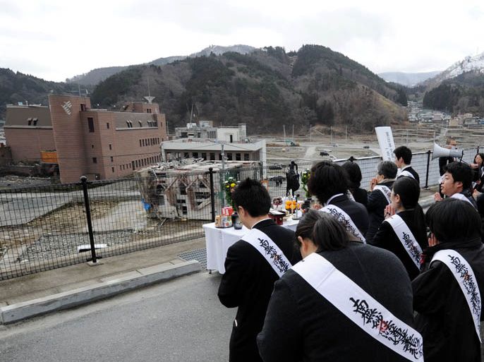 People pray for the victims of the March 11, 2011 tsunami as part of the first year anniversary of the disaster in Onagawa, Miyagi prefecture, on March 11, 2012. Public life in Japan was to pause as the nation marked a year since a huge earthquake and tsunami killed 19,000