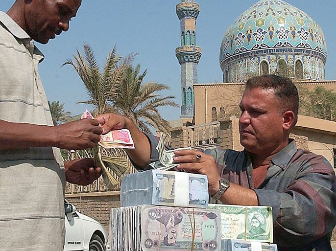 An Iraqi man exchanges his US Dollars for new Iraqi Dinars from a street currency dealer in Baghdad on Wednesday15 October 2003. Coalition forces released today new Iraqi currency. The new Iraqi Dinar is available in six different denominations 50, 250, 1000, 5000,10000 and 25000 Dinar notes. EPA/ALI ABBAS EPA