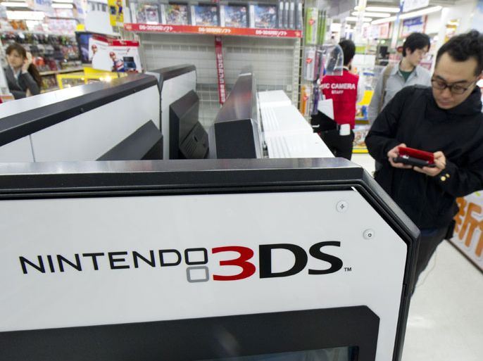 epa03196375 A Japanese businessman shops for Nintendo 3DS software at an electronics store in Tokyo, Japan, 26 April 2012. The net income for the video-game maker is expected at 20 billion yen, or 246 million US dollars, according to Japanese news reports. EPA/EVERETT KENNEDY BROWN