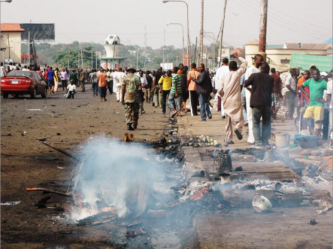 People gather at the site of an explosion in Kaduna on April 8, 2012. A car bomb blast outside a church in northern Nigeria on Easter Sunday killed at least 20 people and put the country on alert over fears of further attacks, rescue officials and residents said. The explosion, a stark reminder of Christmas Day attacks that left dozens of people dead in Africa's most populous nation and largest oil producer, hit the city of Kaduna, a major cultural and economic centre in the north. Motorcycle taxi drivers and passers-by caught much of the blast. AFP PHOTO / STRINGER