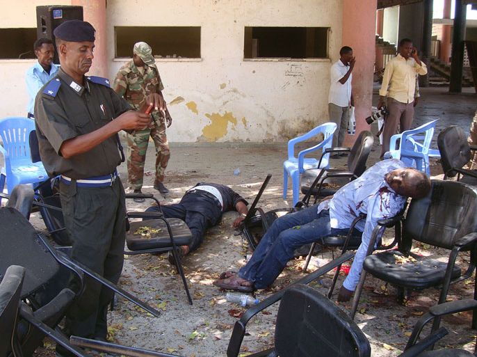 GRAPHIC CONTENT Somalia security officer workS near the bodies on April 4, 2012 of casualties of a suicide attack in Mogadishu. A young woman strapped with explosives blew herself up Wednesday at a ceremony in the Somali national theatre attended by the prime minister and other officials, killing at least two. She detonated her suicide belt as Prime Minister Abdiweli Mohamed Ali was on a podium addressing 200 people gathered to mark the first anniversary of the country's satellite TV network, an AFP reporter who witnessed the incident said. The prime minister, and seven other ministers standing beside him, were unharmed but witnesses said Somali Olympic Committee Aden Yabarow Wiish and Somali Football Federation chief Said Mohamed Nur were killed in the attack. AFP PHOTO/Mohamed ABDIWAHAB