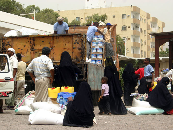 ‪عمال إغاثة يوزعون مساعدات غذائية على يمنيين في مدينة عدن‬ (الفرنسية-أرشيف)