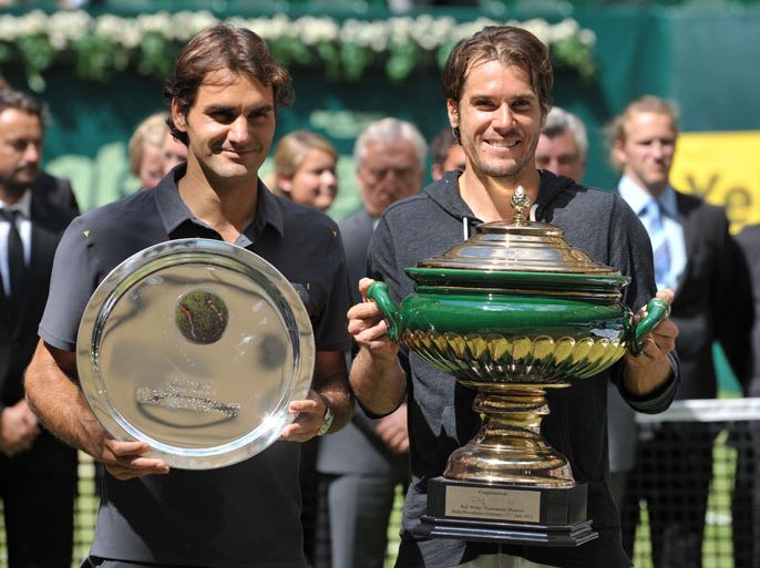 : Tommy Haas (R) of Germany and Switzerland's Roger Federer (L) pose with their trophies after their final match of the ATP Gerry Weber Open tennis tournament in Halle, western Germany, on June 17, 2012. Haas won the match 7-6 (7/5), 6-4. AFP PHOTO / CARMEN JASPERSEN
