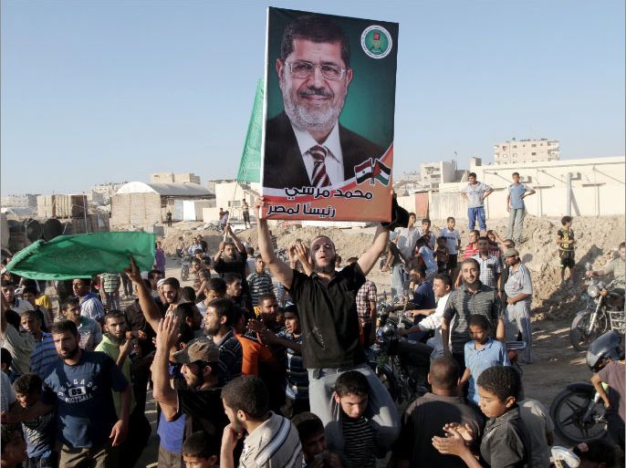 A Palestinian youth waves a picture of Muslim Brotherhood's presidential candidate, Mohamed Morsi, as they celebrate his victory in the Egyptian presidential elections on June 24, 2012 in Rafah town, in the southern Gaza Strip. Arab governments and leaders welcomed the election of Morsi as Egypt's first president following the ouster of Hosni Mubarak. AFP PHOTO/SAID KHATIB