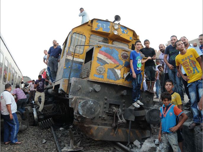 Egyptians gather around a train which is crashed and derailed near Badrashin station south of Cairo on its way to the town of Sohag on July 17, 2012. Four people injured in the accident after five carriages overturned. AFP PHOTO/STR
